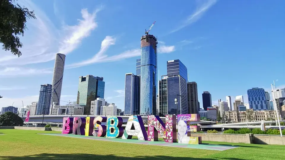 The colourful Brisbane sign at South Bank with the city skyline behind
