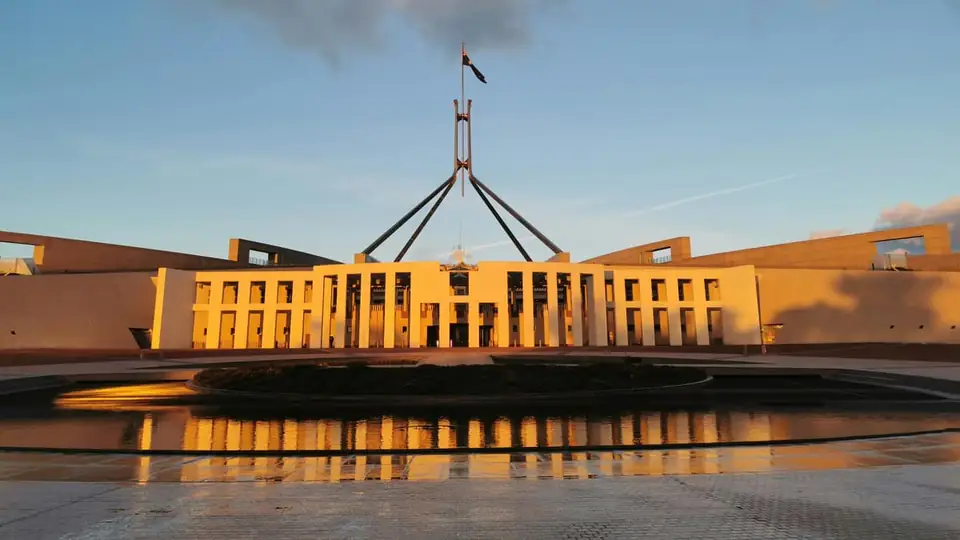 Australian Parliament House reflected in a pool at dusk in Canberra