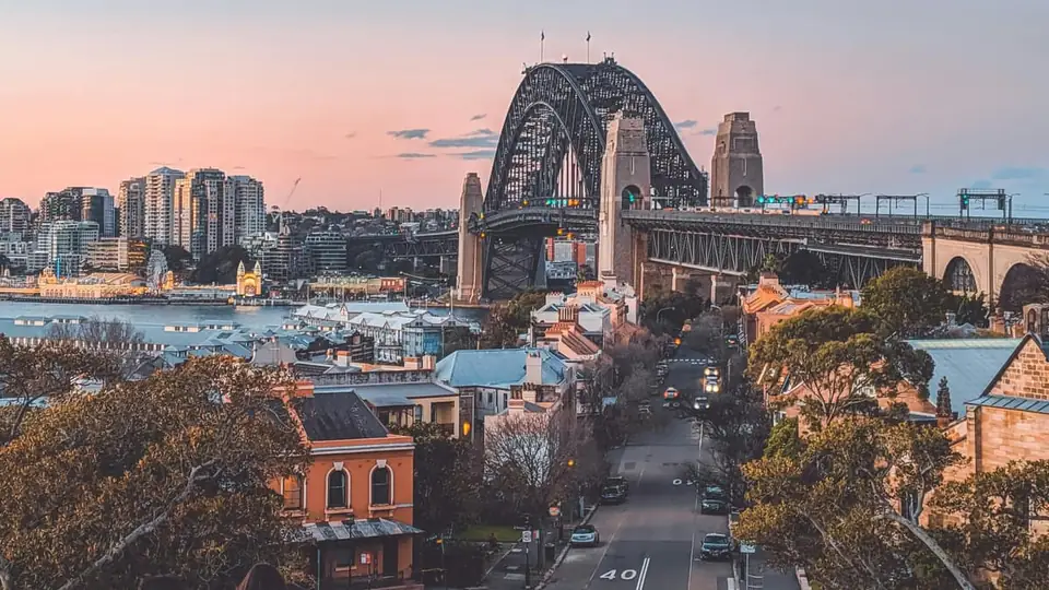 The Sydney Harbour Bridge at dusk above historic terraces