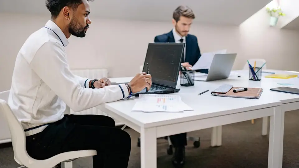 Two professionals reviewing charts and reports in an office